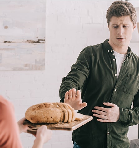 Mann lehnt Brot ab, weil er es nicht verträgt ist. Bei einigen Allergien ist Besserung möglich